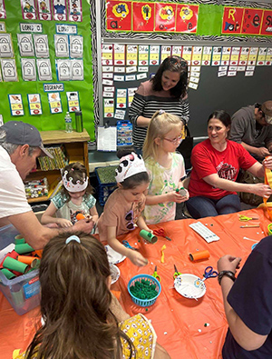 adults helping students with crafts