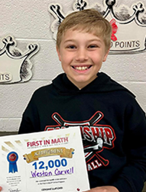 Student holding First in Math award