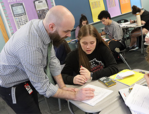 Teacher helping a students at their desk