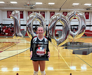 Student holding a volleyball award