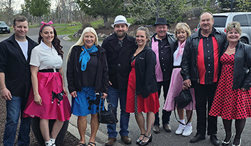 Group of adults dressed in fifties attire outside