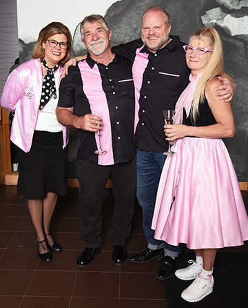 Couples dressed in pink and black attire having fun at the Gala