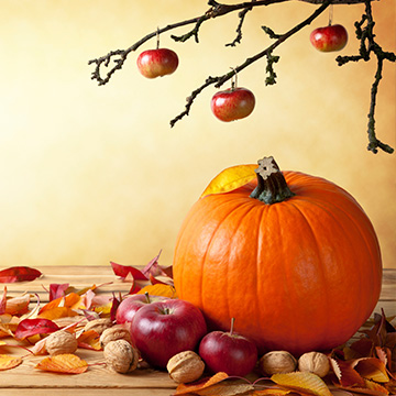 Halloween pumpkin with apples, nuts, and leaves