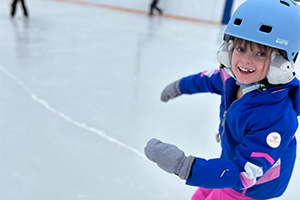 Smiling student ice skating