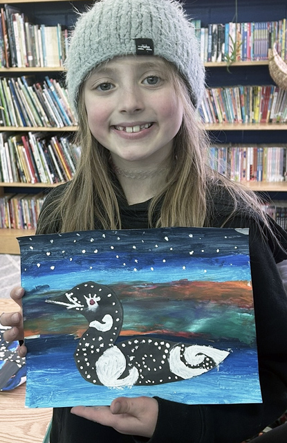 Proud student holding up beautiful artwork of a duck