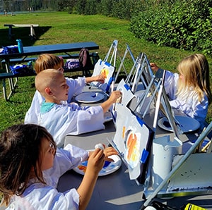 Students painting on easels outside