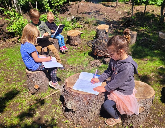 Students writing in journals out in nature
