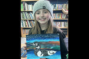 Proud student holding up beautiful artwork of a duck