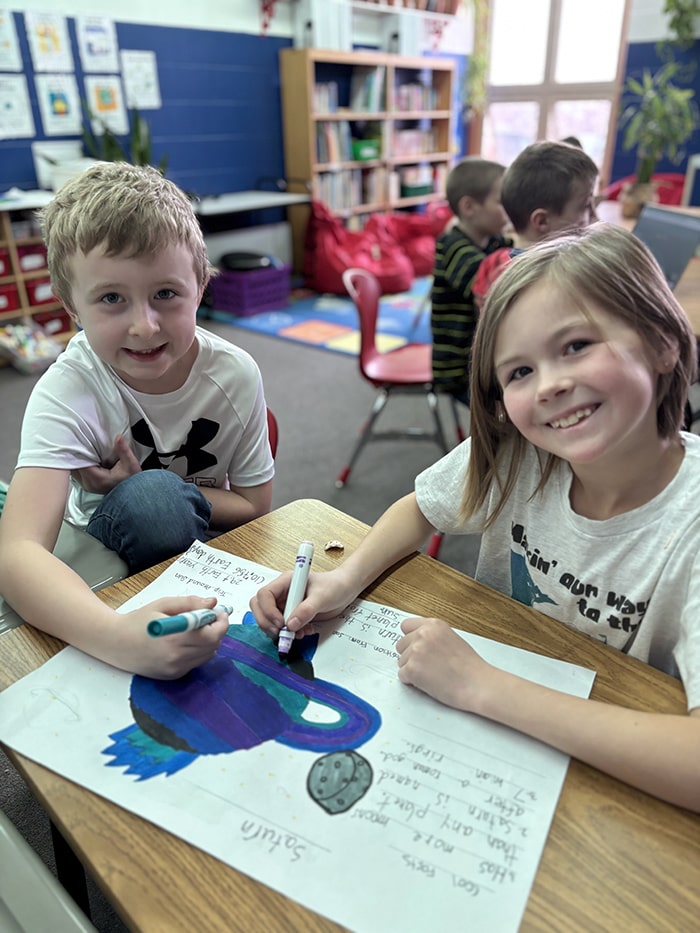 Two happy students coloring together