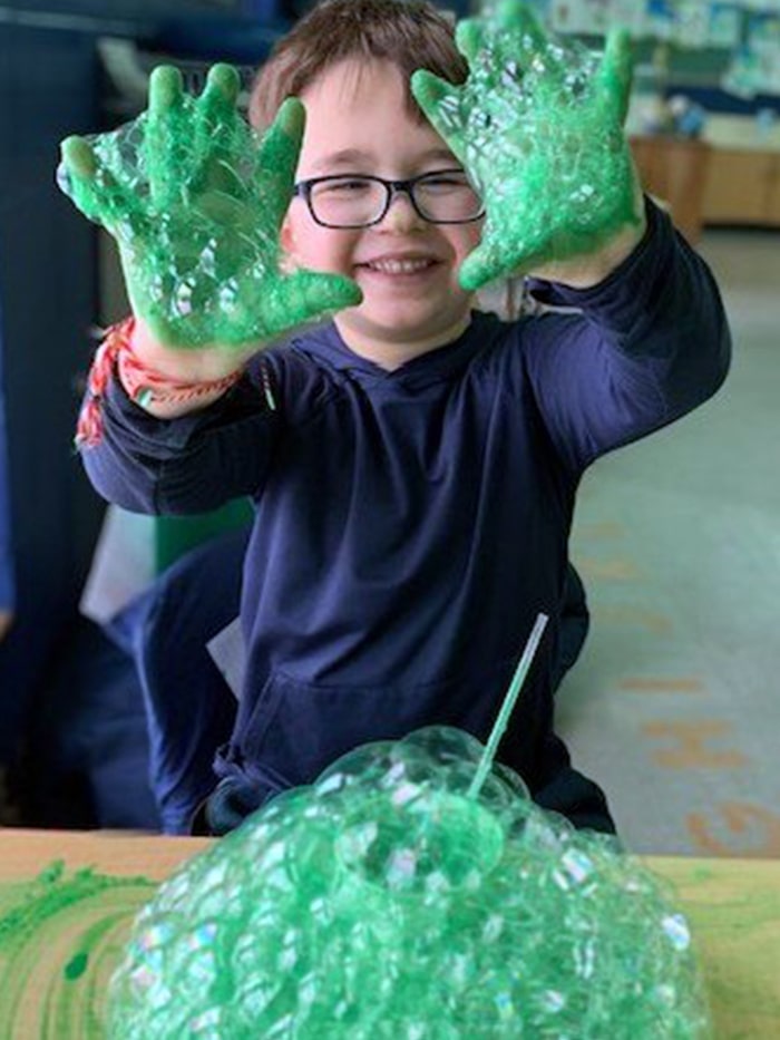 Student having fun with green bubbles