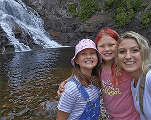 Teacher and two students in front of a waterfall