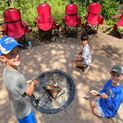 Boys roasting marshmallows in fire pit