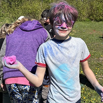 Student covered in colors outside during a fun activity