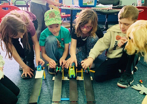 Group of students playing with toy vehicles