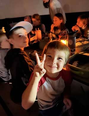 Students eating lunch by lantern light