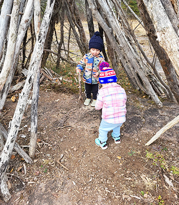 Two students playing outside under some trees
