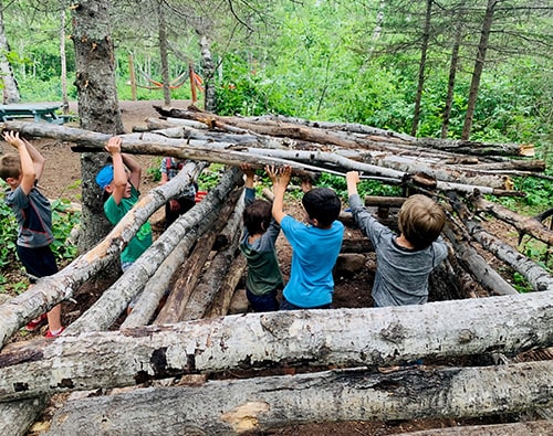 Students building a fort near their campsite