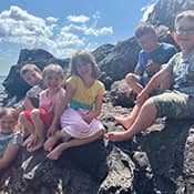 Students sitting on rocks next to the water