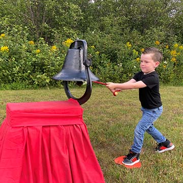 Young student ringing a bell