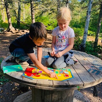 Two students reading a book together outside
