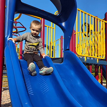Little boy on blue slide