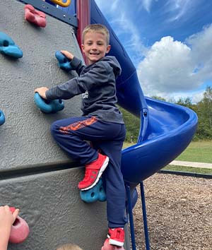 Boy climbing on a playground rock wall