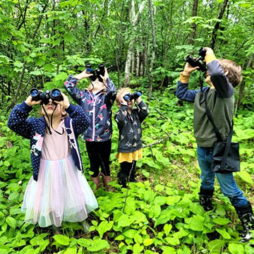 Group of students using binoculars outside