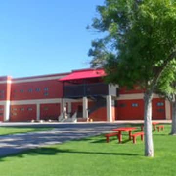 The outside of the school and the lawn with picnic tables