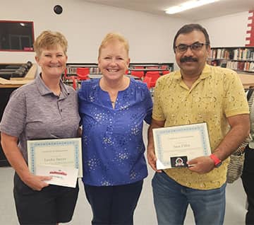 staff holding awards