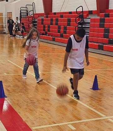 Students practicing basketball in the gym