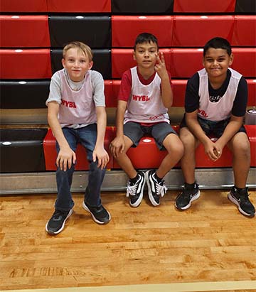 three students sitting on bleachers