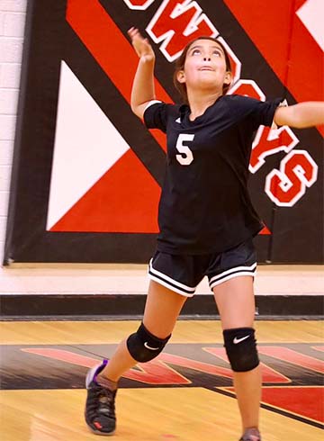 Female student serving a volleyball