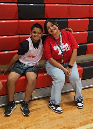 Student and staff sitting on bleachers