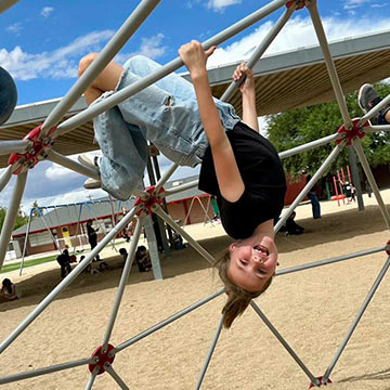Girl smiling and climbing the playground structure Girl smiling and climbing the playground structure