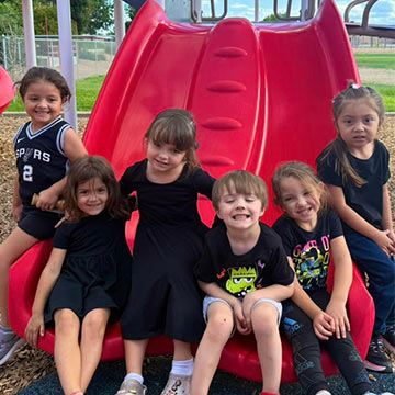 Kids sitting on the slide and smiling