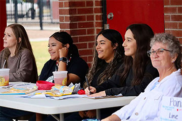 Staff members sitting at a table outside