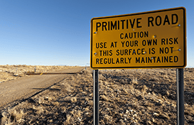Primitive Road sign cautioning drivers to use at their own risk