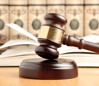 Wooden gavel on a desk with a book