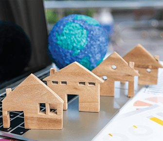 wooden houses next to globe of the Earth