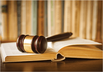 Wooden gavel laying on a book with books in the background