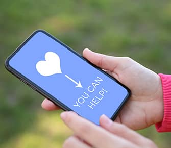 a cell phone with a heart and the words you can help!