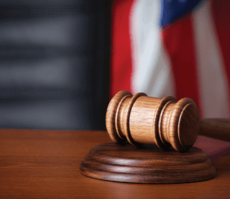 Wooden gavel on desk with USA flag in the background