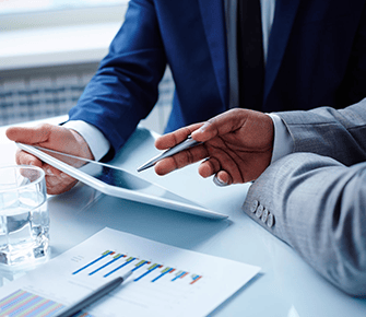 Two men working on an ipad together