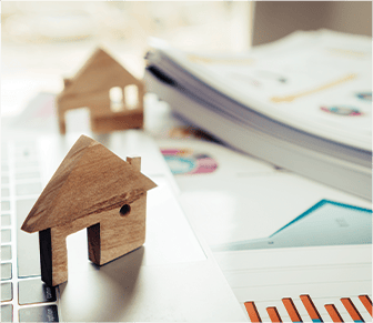 wooden house shapes on top of business plans