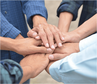 group of adults joining hands