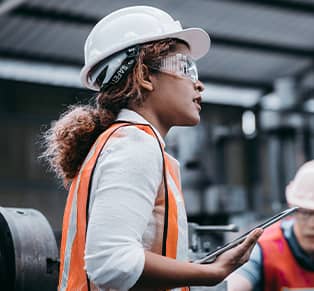 Woman in hard hat surveying building