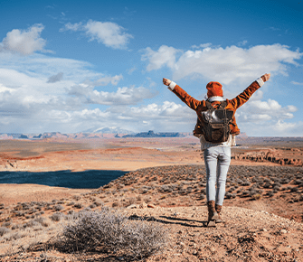 person celebrating at the top of a canyon