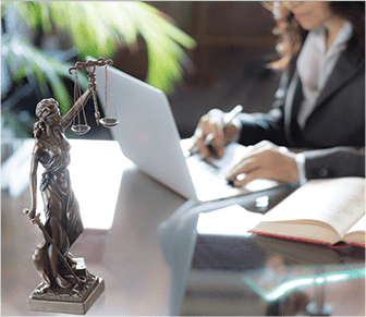 Lady sitting at a desk with a mini justice paper holder 