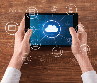 An adult holding a tablet computer with an internet cloud concept