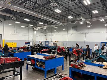 A large room with many engine blocks for students to examine